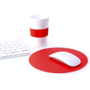 A red mousepad with a white mouse and a white cup featuring a red band, alongside a white keyboard.