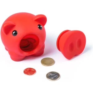A red piggy bank made of silicone, featuring a removable stopper and scattered coins nearby, alongside a small coin.