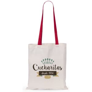 A cream tote bag featuring red handles and a logo design with "Cucharitas" and decorative elements.