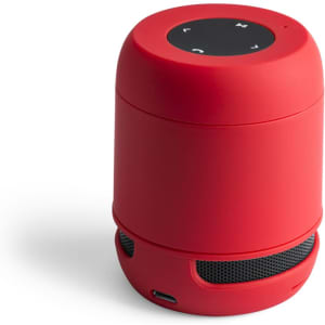 A red portable speaker with a cylindrical shape and control buttons on the top. It features a mesh speaker grille at the bottom and has a logo.