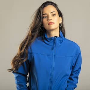 A blue soft shell jacket is worn by a model, featuring a zip closure and a branding logo.