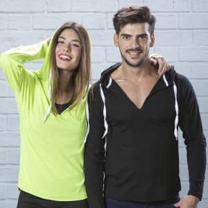 A black and a bright green hooded long-sleeve T-shirt, displayed on a male and female model against a brick background.