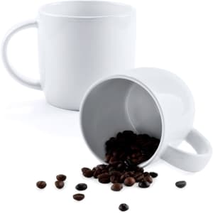 A white coffee mug, upright and another tipped over with coffee beans spilling out, featuring a logo.