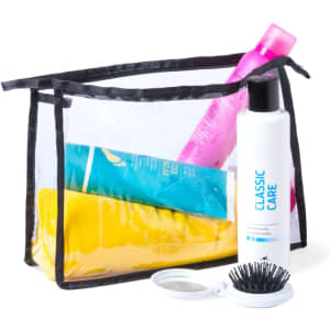 A transparent toiletry bag with a black trim containing shampoo, conditioner, a yellow towel, and a hairbrush.