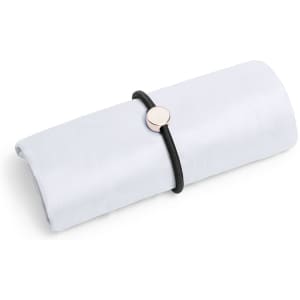 A folded white bag secured with a black elastic band, featuring a decorative round clasp.