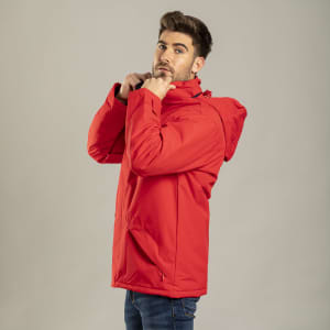 A man wearing a bright red puffer jacket with a hood, adjusting the collar. The jacket features a logo.