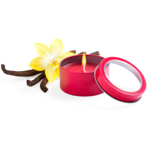 A red aromatic candle in a tin with a yellow flower and vanilla pods beside it.