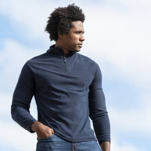 A navy blue polar fleece jacket on a model, featuring a half-zip neck and fitted sleeves, set against a cloudy sky.