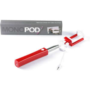 A red selfie stick with a white phone holder and a connecting cable, packaged in a box with branding.
