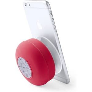 A red Rariax Speaker positioned against a smartphone, featuring a circular design and control buttons on the front.