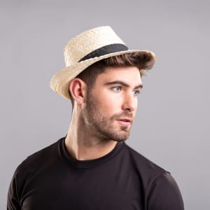 A straw hat in natural tones with a black band, worn by a man in a black t-shirt.