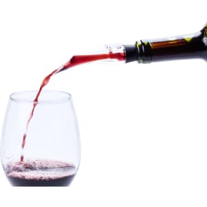 A wine bottle pouring red wine into a glass, with a sleek aerator attachment. The glass is partially filled.