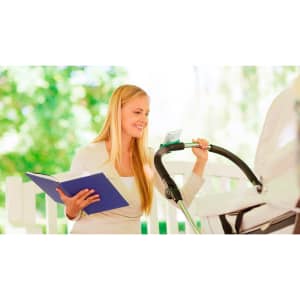 A woman with long blonde hair smiles while holding a blue folder and adjusting a phone holder attached to a stroller.