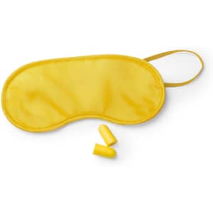 A yellow sleep mask with two earplugs placed alongside it, featuring a smooth fabric surface.