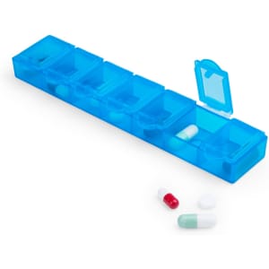 A blue pillbox with multiple compartments, containing various capsules and tablets, including red, white, and green pills.