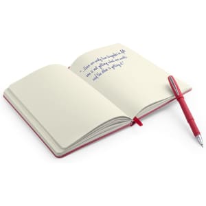 A red notebook with blank pages opened, accompanied by a red pen resting on it.