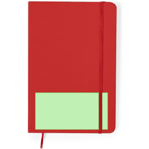 A red notebook with a green patch and an elastic band closure. It features a logo on the front.