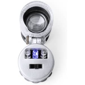 A compact microscope in silver, featuring a lens and LED lights, with a round base for stability.