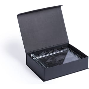 A clear glass plaque in an open black gift box, lined with black fabric. The plaque has a sleek, rectangular design.