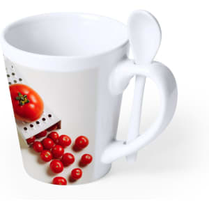 A white coffee mug featuring a design of tomatoes and a spoon attached to the handle.