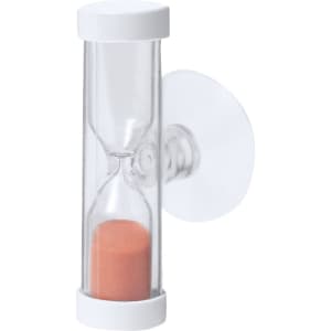 A transparent sand timer with white ends and an orange sand fill, attached to a surface with a suction cup.