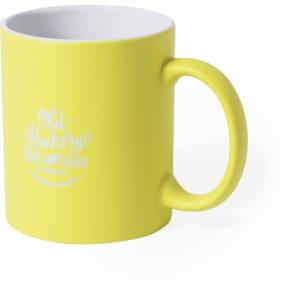 A yellow coffee mug with a curved handle and a branding logo on the front. The interior is white.