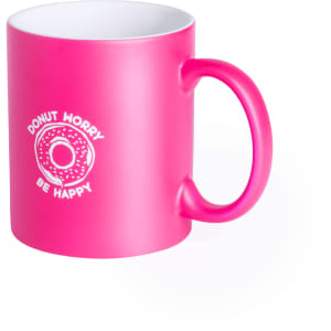 A pink coffee mug featuring the text "Donut Worry Be Happy" and a circular doughnut graphic.