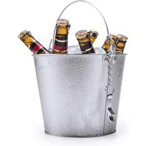 A silver ice bucket filled with ice and several beer bottles, featuring condensation on the exterior.