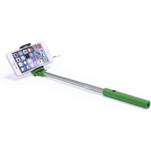 A green selfie stick with a silver extendable arm holding a smartphone displaying various app icons.