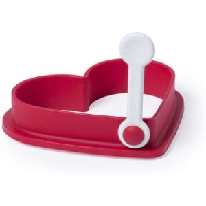 A heart-shaped mould in red silicone with a white handle for easy lifting. It includes a logo on the side.