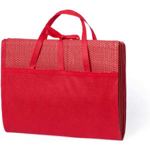 A red beach mat with handles, featuring a textured surface and a foldable design for easy transport.