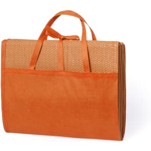 An orange beach mat with a woven texture and carrying straps, featuring a pocket on the front.