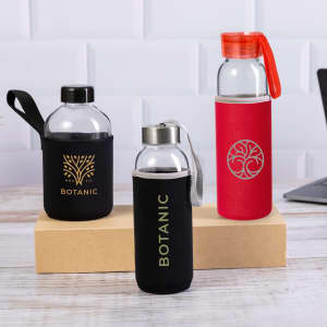 A drink bottle trio featuring a clear bottle with a black sleeve, a clear bottle with a silver lid, and a red bottle with a sleeve.