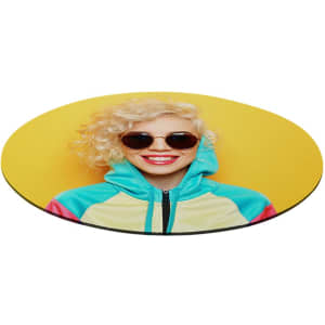 A round mouse pad featuring a smiling person with curly blonde hair, wearing sunglasses and a colourful hoodie against a yellow background.