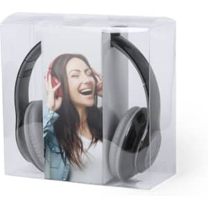 A pair of black and grey headphones are displayed in a clear packaging with a smiling woman wearing red headphones.