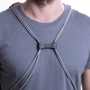 A close-up of grey drawstring bag straps worn over a grey T-shirt, featuring a plastic adjusting toggle.