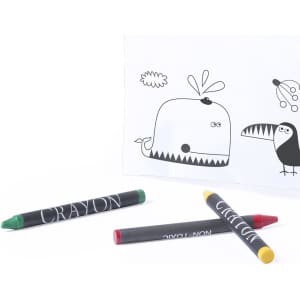 A pencil case in white with black illustrations, accompanied by three colourful crayons: green, red, and yellow.