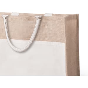 A tote bag featuring a natural jute and cream design, with a rope handle. The bag has a simple, elegant aesthetic.