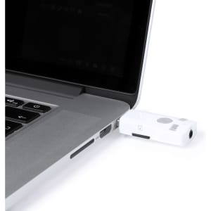 A white Bluetooth receiver plugged into a laptop's USB port, showcasing a compact design for technology use.