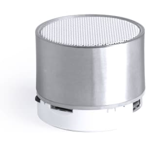 A compact silver speaker with a textured top and a white base. It features a logo on the side.