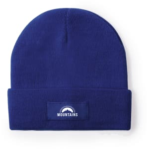 A blue beanie featuring a foldable cuff and a logo patch on the front.