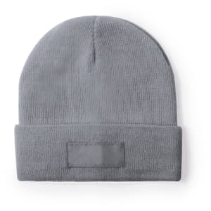 A grey beanie hat with a folded cuff and a branding label on the front.