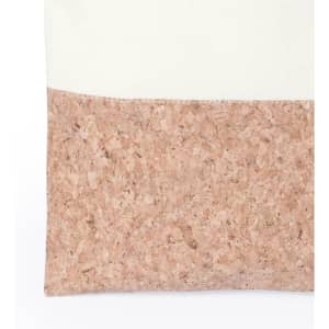 A tote bag featuring a creamy upper section and a textured pink cork lower section, with a logo present.