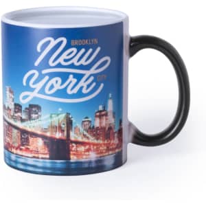 A coffee mug featuring a night-time cityscape of Brooklyn Bridge and skyline, with a black handle and a logo.