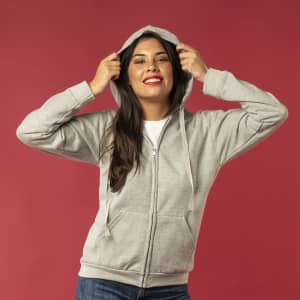 A grey adult hooded sweatshirt with a zipper, featuring a woman smiling and wearing it.