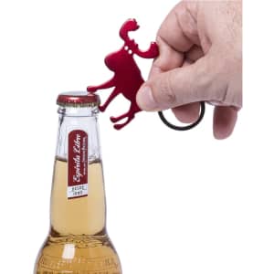 A red bottle opener keyring shaped like a moose, being used to open a glass drink bottle.