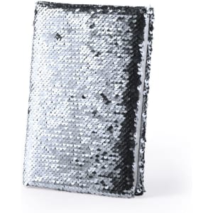 A sleek notepad covered in silver and black sequins, featuring a simple design and a logo.
