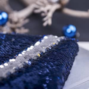 A navy blue sequined notepad with silver and clear sequins, adorned with decorative blue accents.