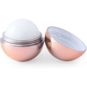 A metallic pink lip balm container open to reveal a white balm inside. The product features a logo on its exterior.
