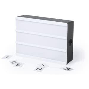 A black and white light box with three panels, accompanied by scattered letter tiles.